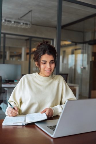 Young,Hispanic,Woman,Using,Laptop,Computer,For,Business,Studying,,Watching